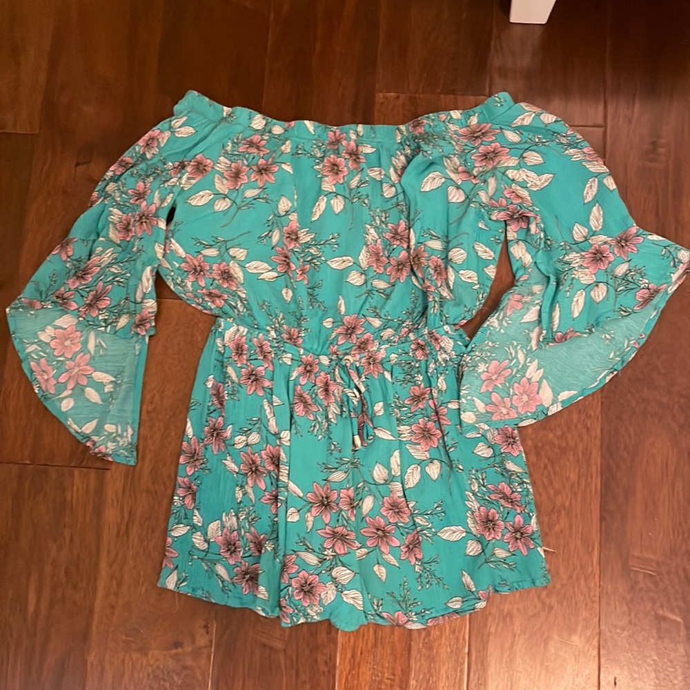 Pretty floral green romper with purple flowers and white leaves.